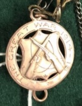 Small gold medallion with lettering both sides
