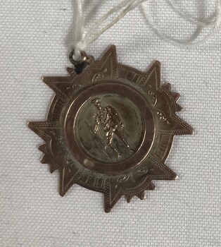 Star shaped medallion with string and tag attached