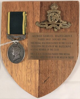 Wooden plaque with medal. badge and engraved plate.