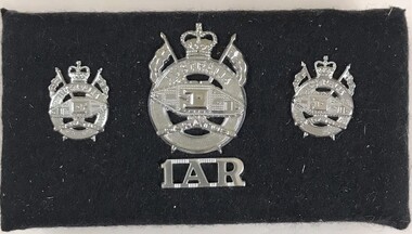 Set of silver badges mounted on fabric board