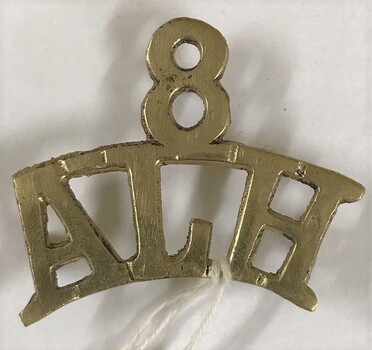 Metal badge with number and letters
