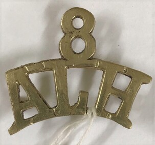 Metal badge with number and letters