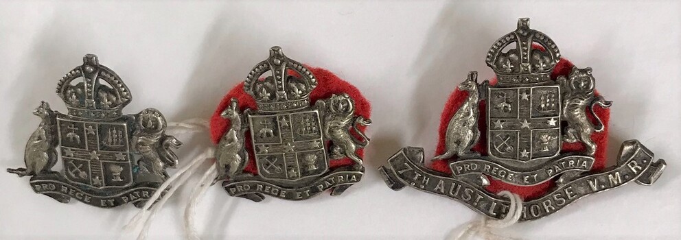 Three metal badges with fabric backing