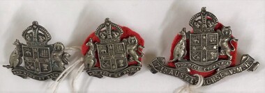Three metal badges with fabric backing