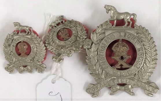 Three metal badges with fabric backing