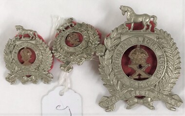 Three metal badges with fabric backing