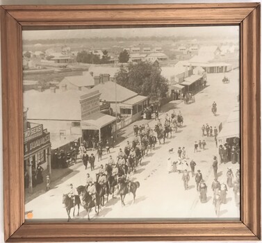 Framed photograph of soldiers on horses in town