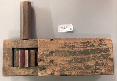 A wooden box with a cog and handle