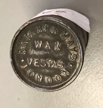 Small metal cylinder with printing on lid