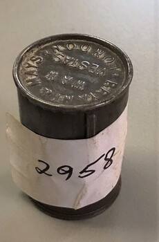 Metal cylinder with sticky label wrapped round it.