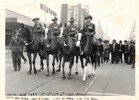 Four soldiers on horseback in city street