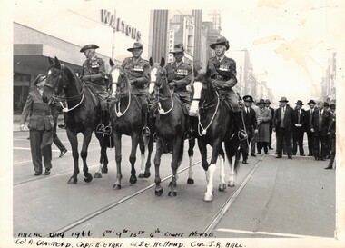 Four soldiers on horseback in city street