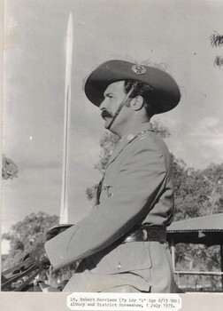 Soldier with plumes in hat and holding a sword.
