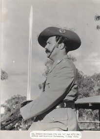 Soldier with plumes in hat and holding a sword.