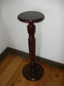 Mahogany vase stand with turned and fluted pedestal.