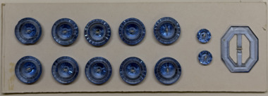 12 buttons and a buckle on white card, 1930s