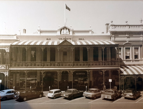 double storey building with cars parked at front