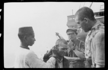 native boy cleaning ears of soldier