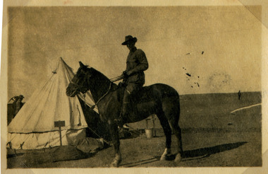 soldier posing on horse in camp