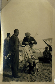 soldier getting haircut in camp