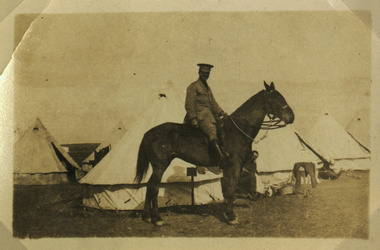 soldier posing on horse in camp