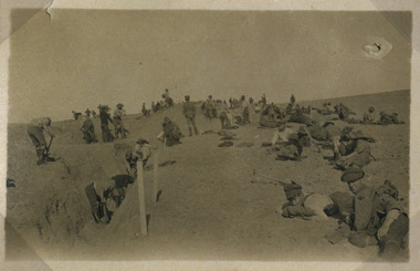 Soldiers digging trench and resting