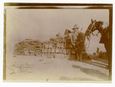 soldier posing next to supplies, robertson thomas140.tif