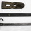  Bayonet unsheathed laid flat by metal scabbard with brown leather belt holder on a white background