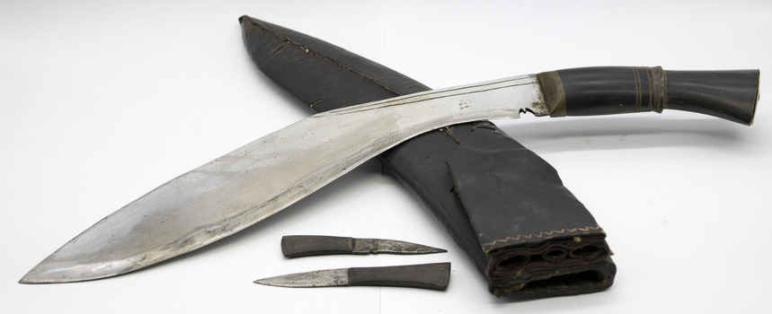 Detail showing blade and two smaller blades unsheathed from scabbard. Scabbard has two small holes at opening for smaller blades