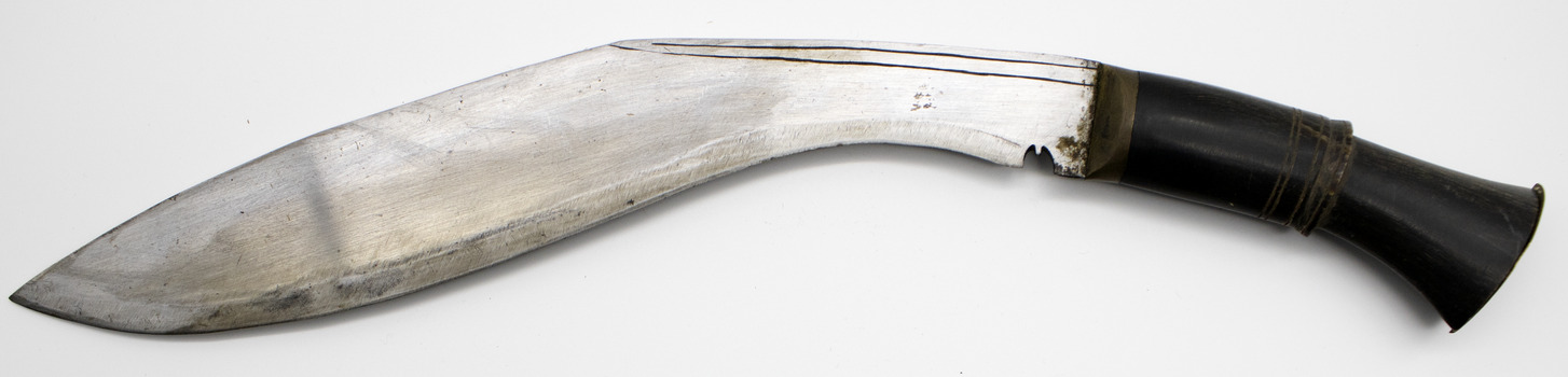 Metal blade, curved large dagger with dark brass handle. Side view on white background