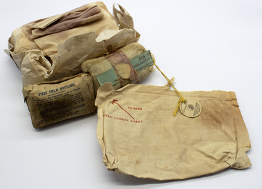 Canvas pouch containing rolled and folded bandages, a couple in packets with printed instructions