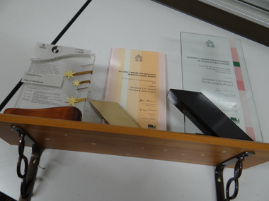 3 plaques on a shelf