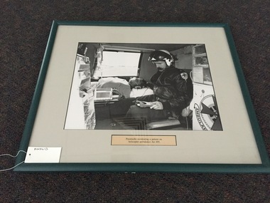 Photograph, framed, Paramedic monitoring a patient on helicopter ambulance Air 495