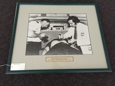 Photograph, framed, Early defibrillator in use in car 208, the first MICA vehicle deployed by VCAS (Victorian Civil Ambulance service)1971