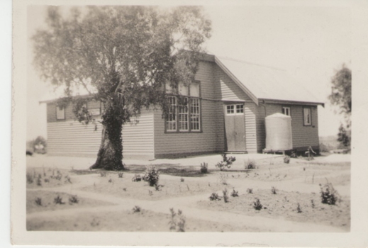 A sepia photograph with a cream border or a weatherboard rural school building.