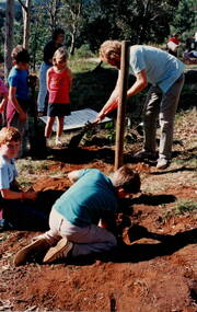 here children and an adult planting trees.