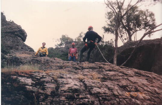 Three men doing rock climbing.