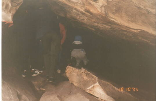 A boy entering one of the caves at Hanging Rock.