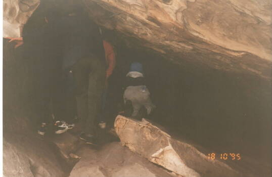 A boy entering one of the caves at Hanging Rock.