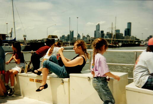 Six children having a ferry trip on the Yarra River with a view of Melbourne's skyline run the background. 