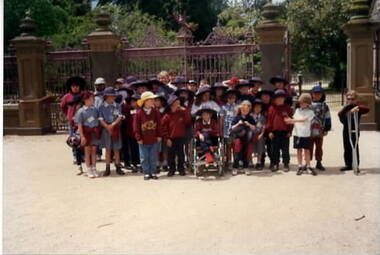 Children assembled outside large gates.