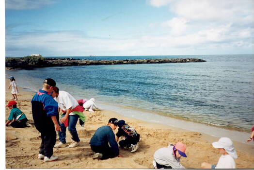 Children at the water's edge preparing to make sandcastles at Williamstown Beach.