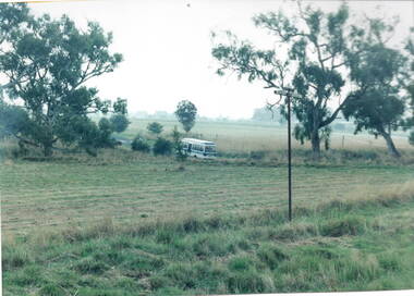 A small school bus is leaving a parkland at the ended an excursion.