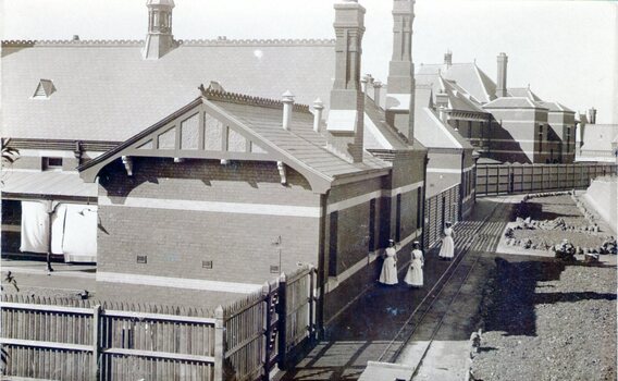 A photograph of F3 ward at the former Sunbury Asylum with three nurses standing outside the building.