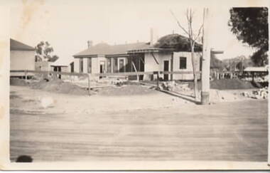 A single storey building being demolished. 