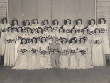 Twenty Five debutantes with their teacher are posing for their official photograph.