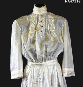 Cream silk wedding dress. High neck with a stand up shaped collar in the Queen Mary style.
