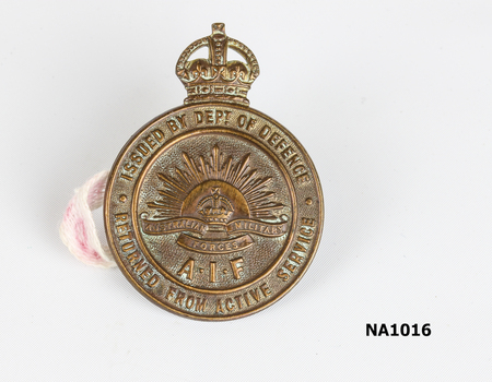 Silver coloured medal for Empire Day 1909 on purple ribbon