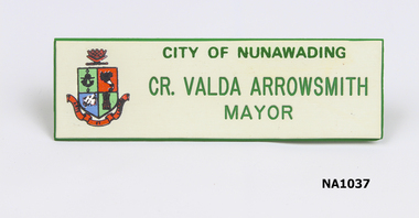 White oblong badge with 'City of Nunawading'/Cr. Valda Arrowsmith/Mayor' written in green. 