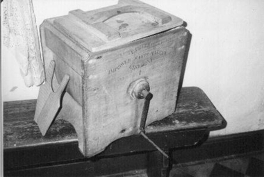 Large lidded wooden box with metal turning handle on outside. 